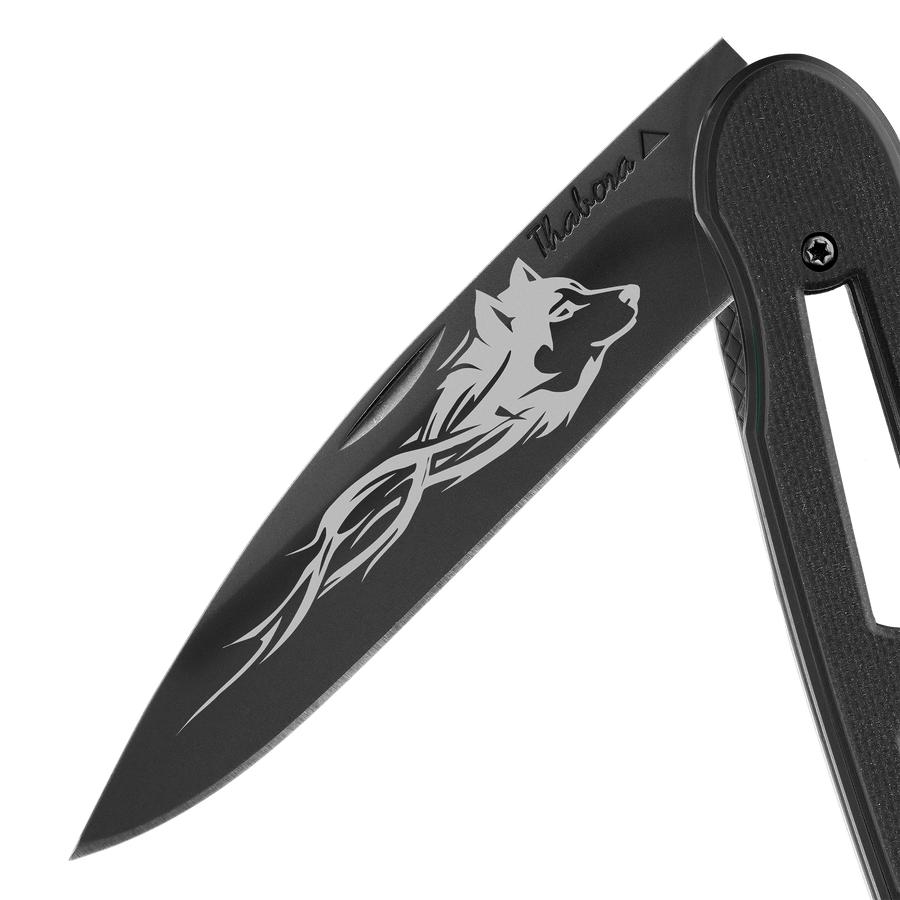 Couteau acier finition titane noir plaquette ajourée résine g10 noir motif «loup tribal»