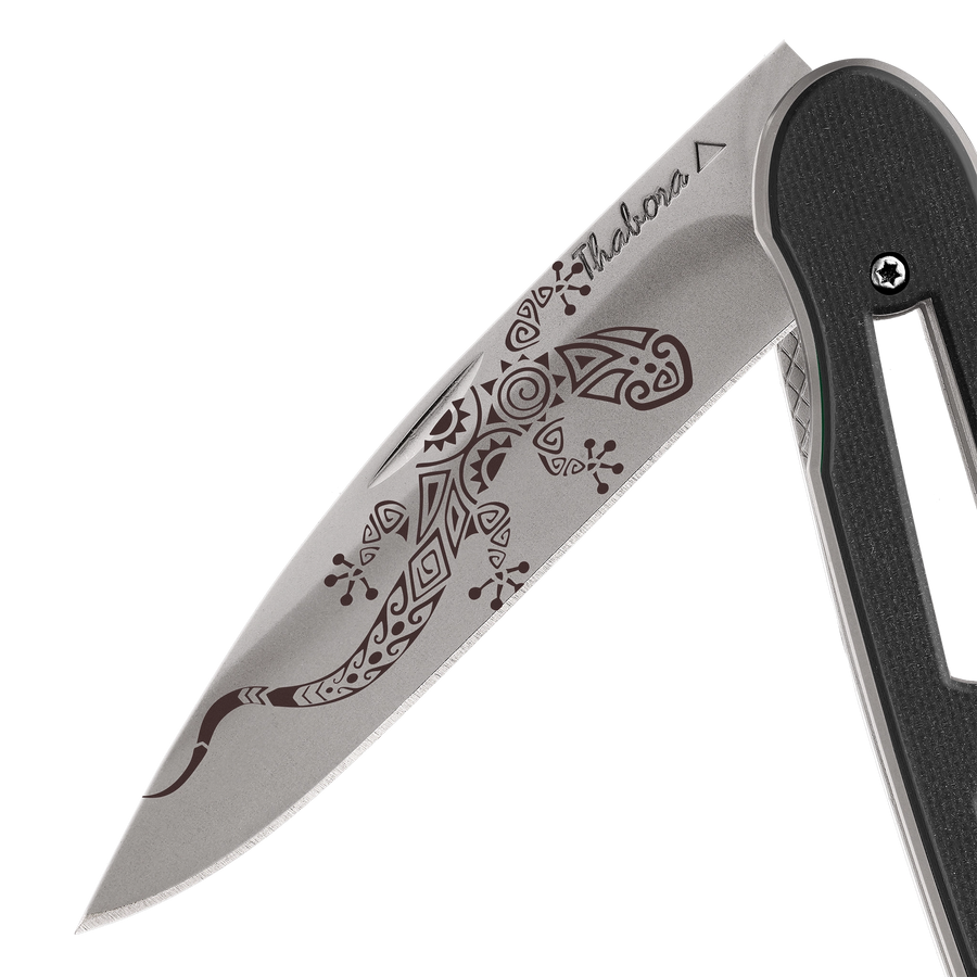 Couteau acier finition titane gris plaquette ajourée résine g10 noir motif «salamandre tribale»