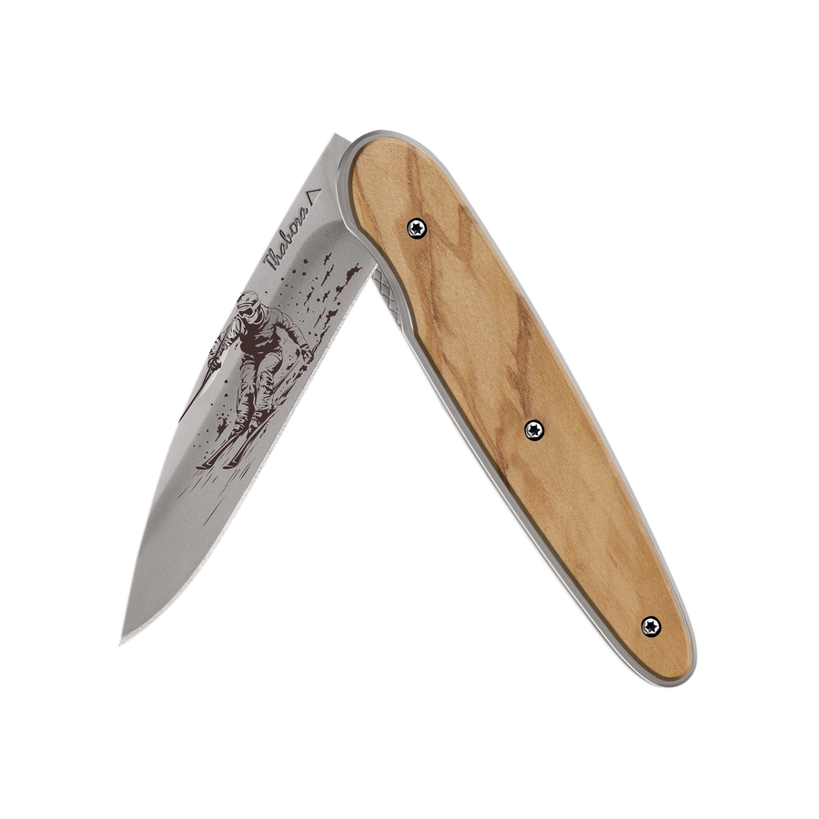 Couteau acier finition titane gris plaquette pleine bois clair motif «skieur»