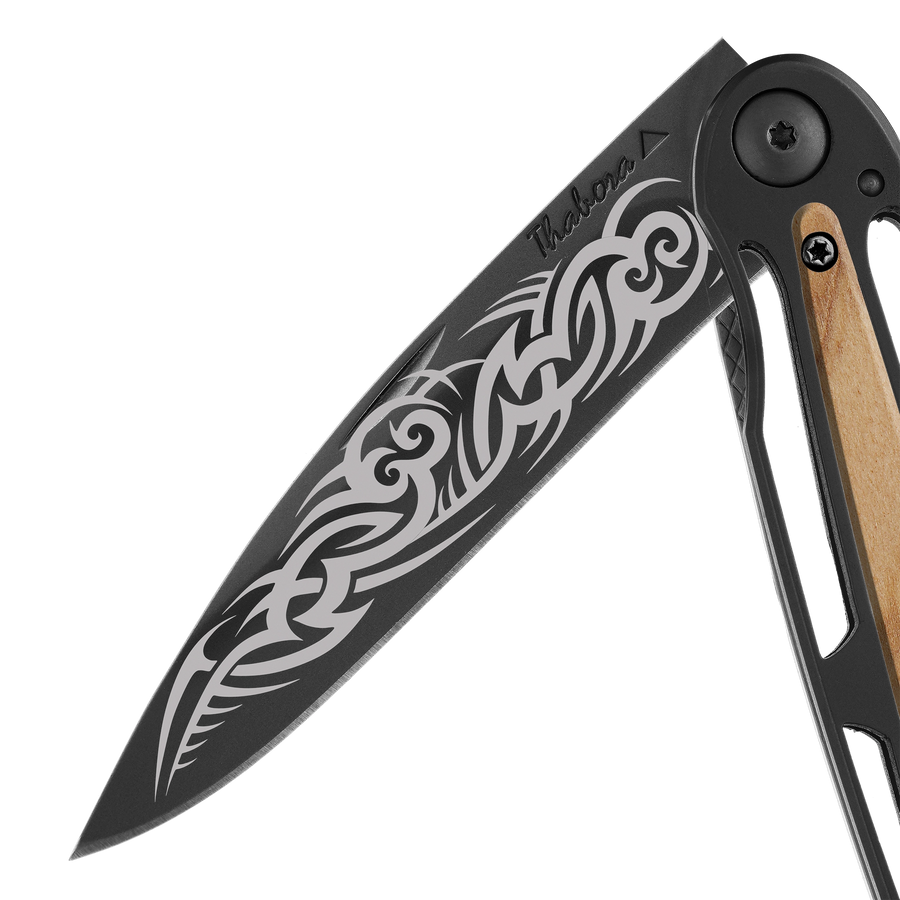 Couteau acier finition titane noir plaquette centrale bois clair motif «tribal gothique»
