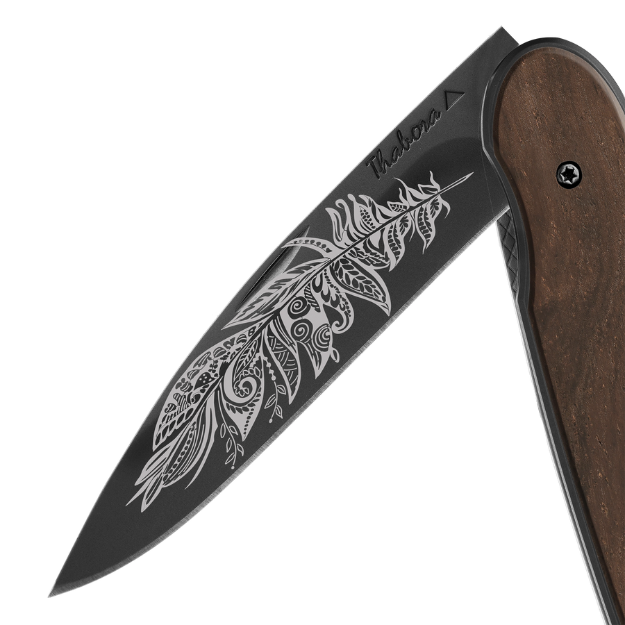 Couteau acier finition titane noir plaquette pleine bois foncé motif «plume polynesienne»