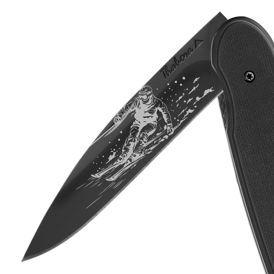 Couteau acier finition titane noir plaquette pleine résine g10 noir motif «skieur»