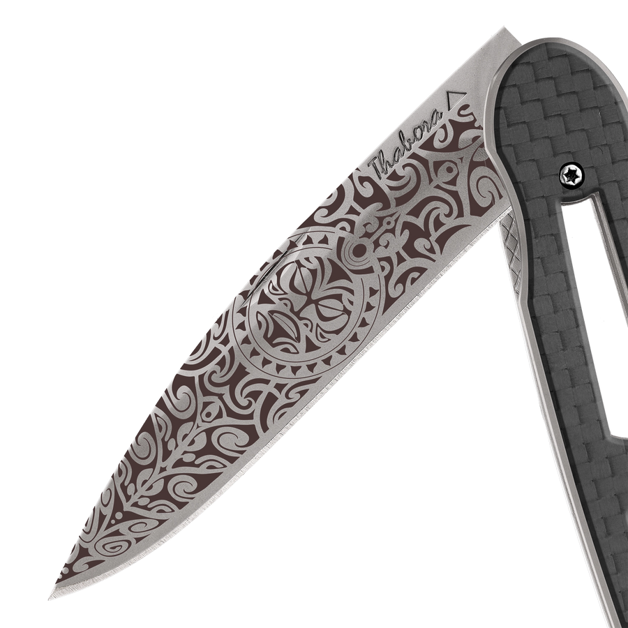 Couteau acier finition titane gris plaquette ajourée carbone motif «tiki»