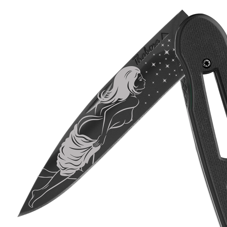 Couteau acier finition titane noir plaquette ajourée résine g10 noir motif «femme dénudée»