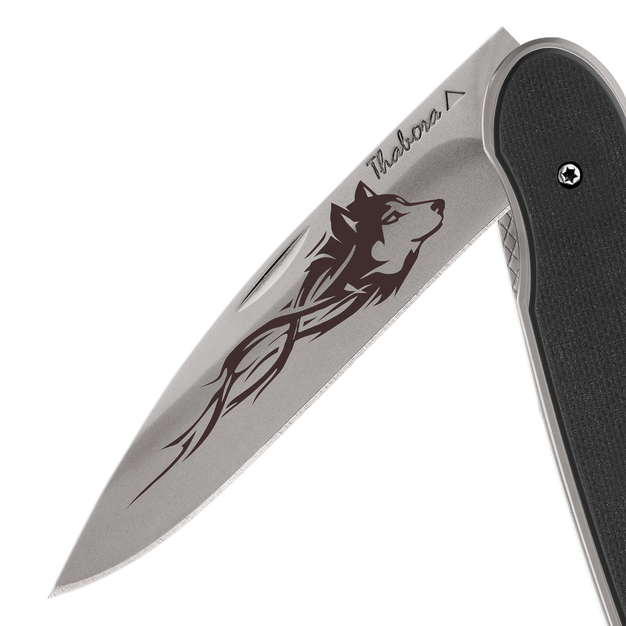 Couteau acier finition titane gris plaquette pleine résine g10 noir motif «loup tribal»