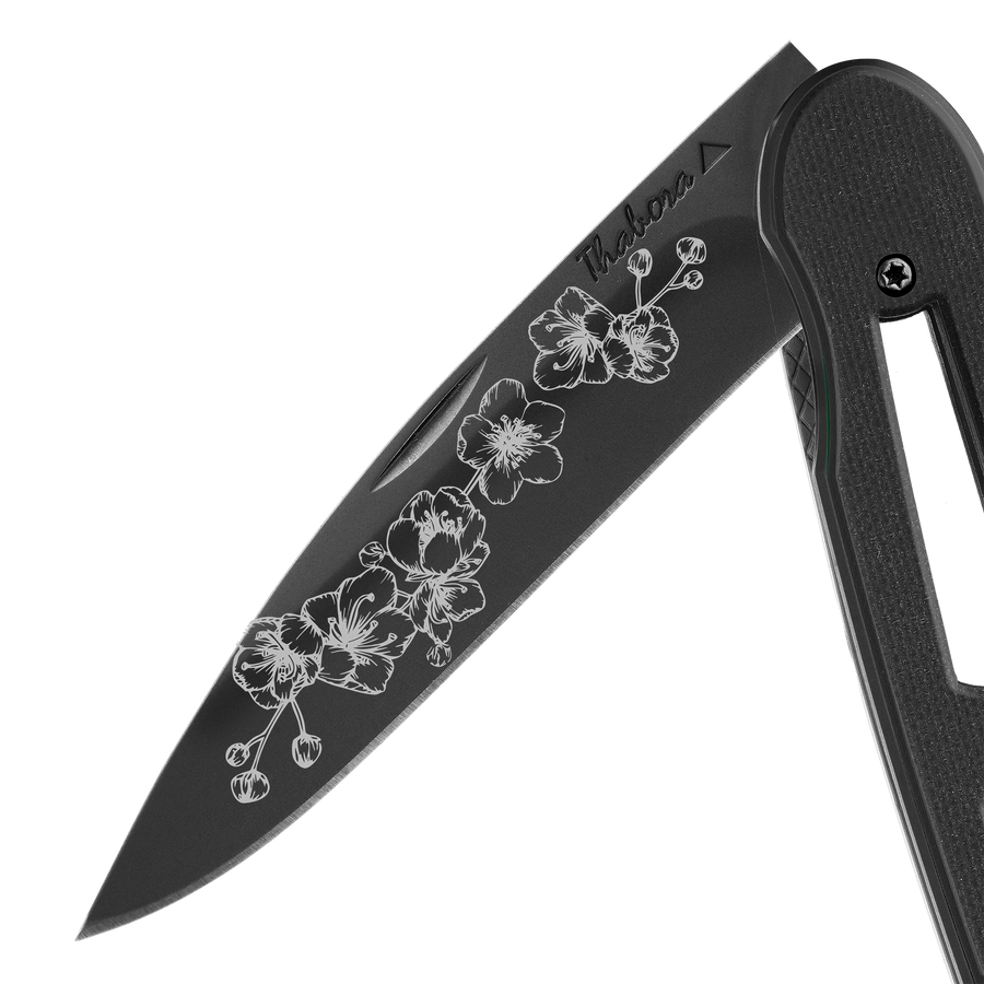 Couteau acier finition titane noir plaquette ajourée résine g10 noir motif «arbre fleuri»