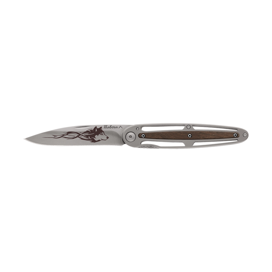 Couteau acier finition titane gris plaquette centrale bois foncé motif «loup tribal»