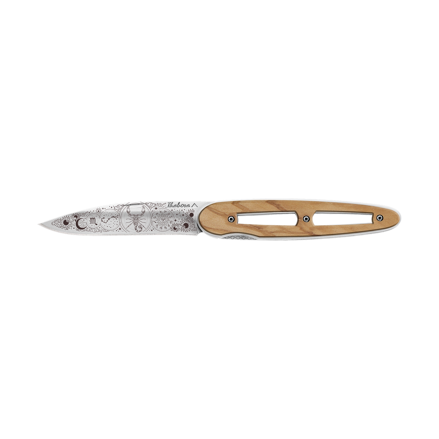 Couteau acier finition brillante plaquette ajourée bois clair motif «zodiaque scorpion»