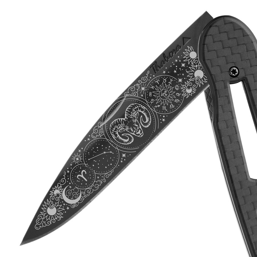 Couteau acier finition titane noir plaquette ajourée carbone motif «zodiaque bélier»