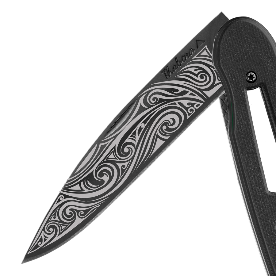 Couteau acier finition titane noir plaquette ajourée résine g10 noir motif «volutes»