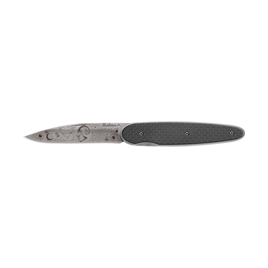 Couteau acier finition titane gris plaquette pleine carbone motif «zodiaque capricorne»