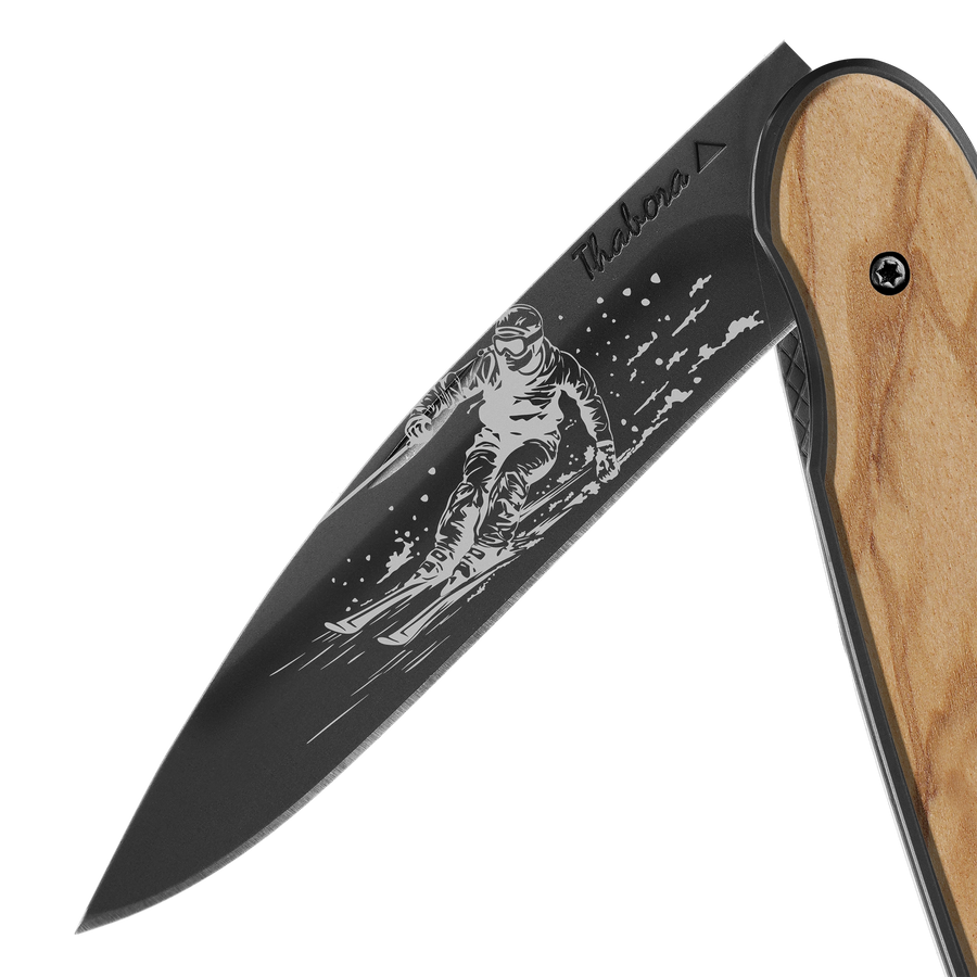 Couteau acier finition titane noir plaquette pleine bois clair motif «skieur»