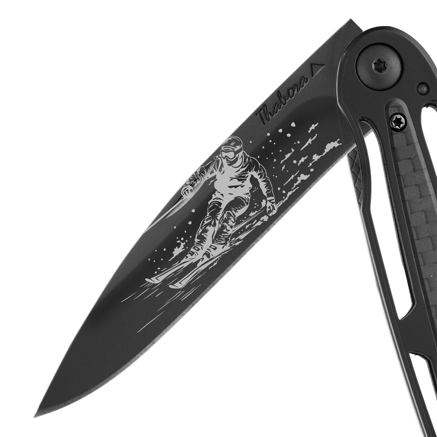 Couteau acier finition titane noir plaquette centrale carbone motif «skieur»
