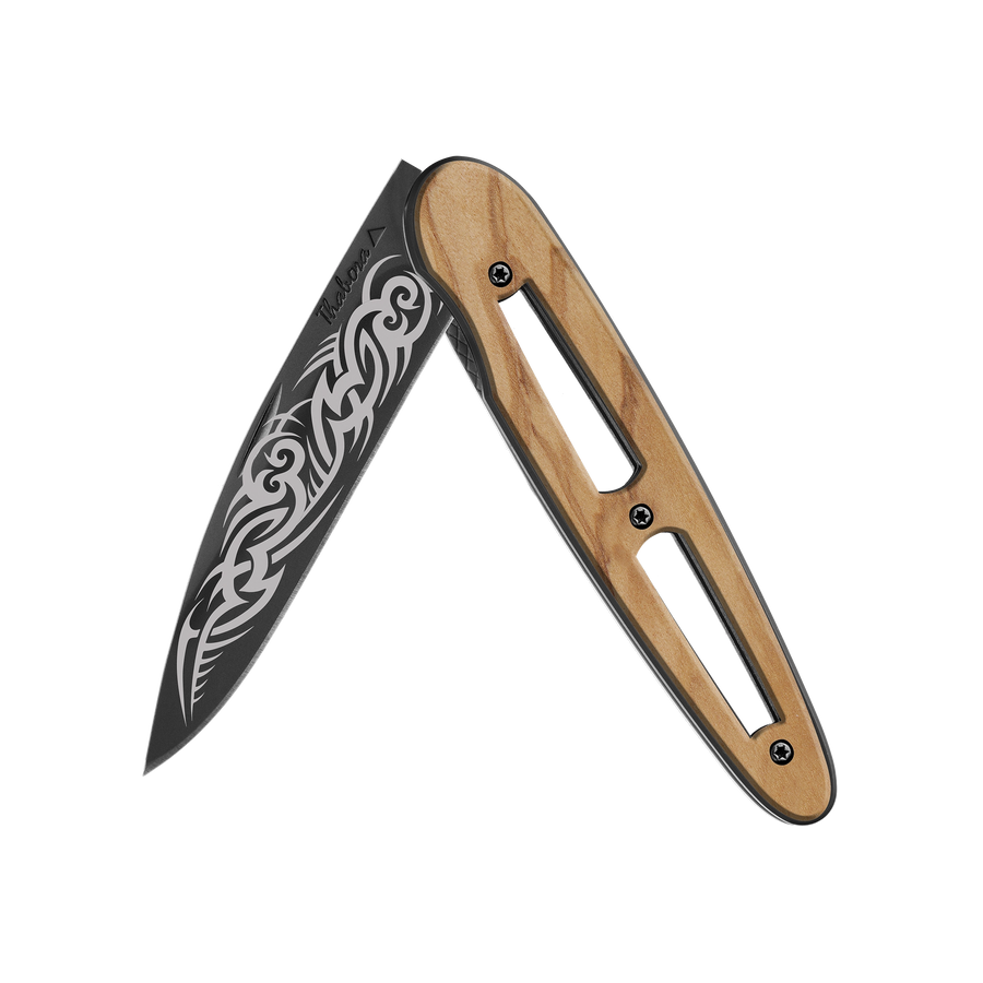Couteau acier finition titane noir plaquette ajourée bois clair motif «tribal gothique»