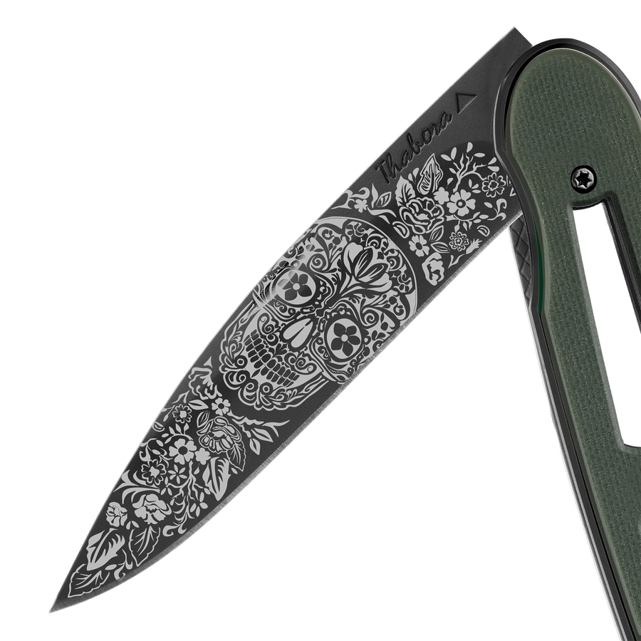 Couteau acier finition titane noir plaquette ajourée résine g10 kaki motif «tête mexicaine»