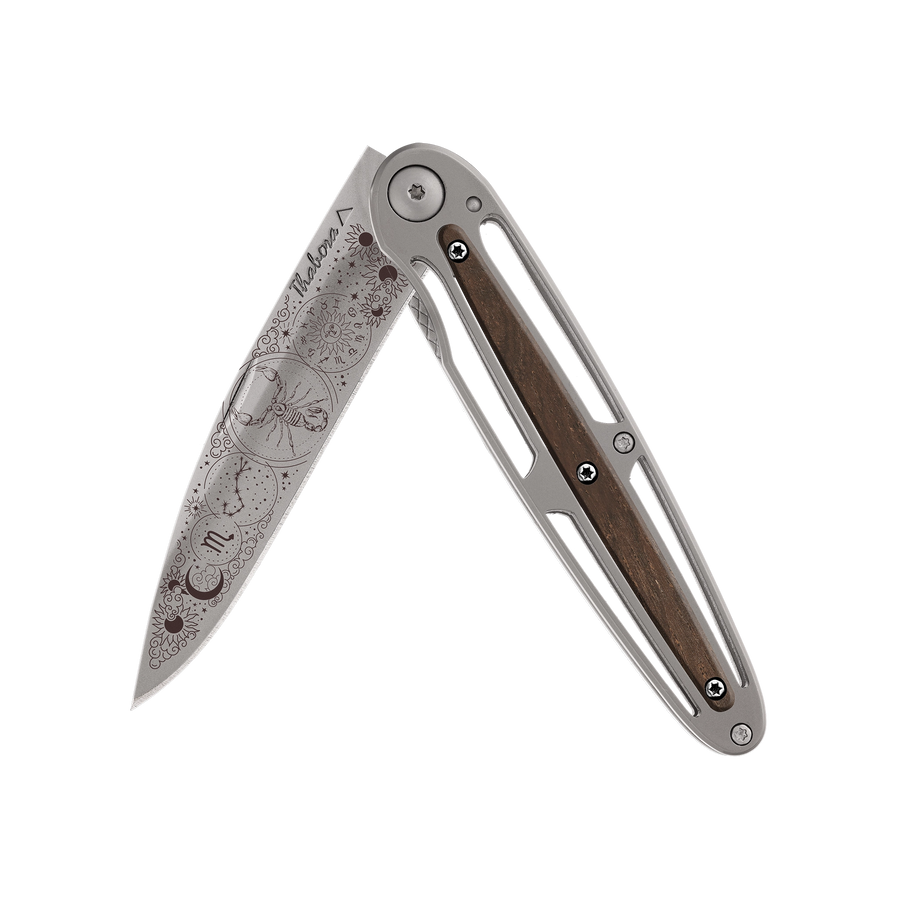 Couteau acier finition titane gris plaquette centrale bois foncé motif «zodiaque scorpion»