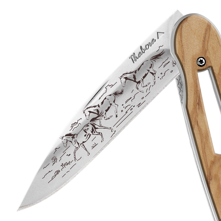 Couteau acier finition brillante plaquette ajourée bois clair motif «chevaux sauvages»