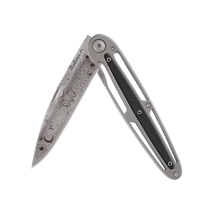 Couteau acier finition titane gris plaquette centrale résine g10 noir motif «zodiaque bélier»