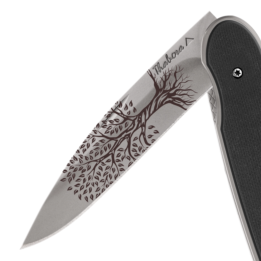 Couteau acier finition titane gris plaquette pleine résine g10 noir motif «arbre de vie»