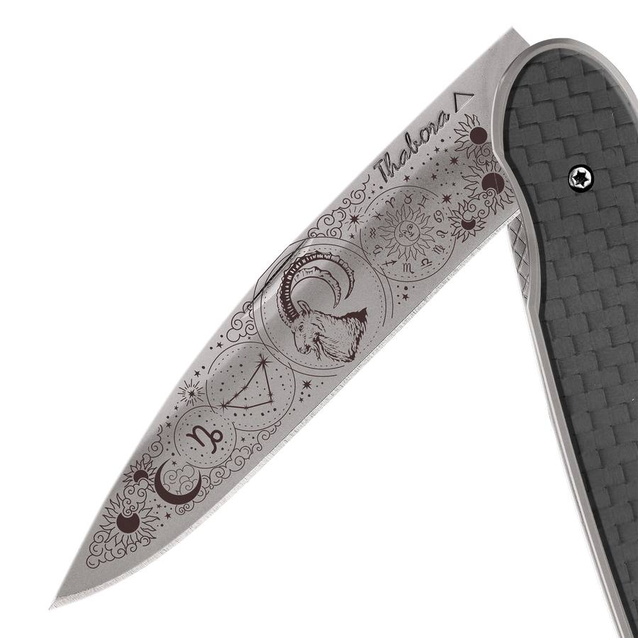 Couteau acier finition titane gris plaquette pleine carbone motif «zodiaque capricorne»