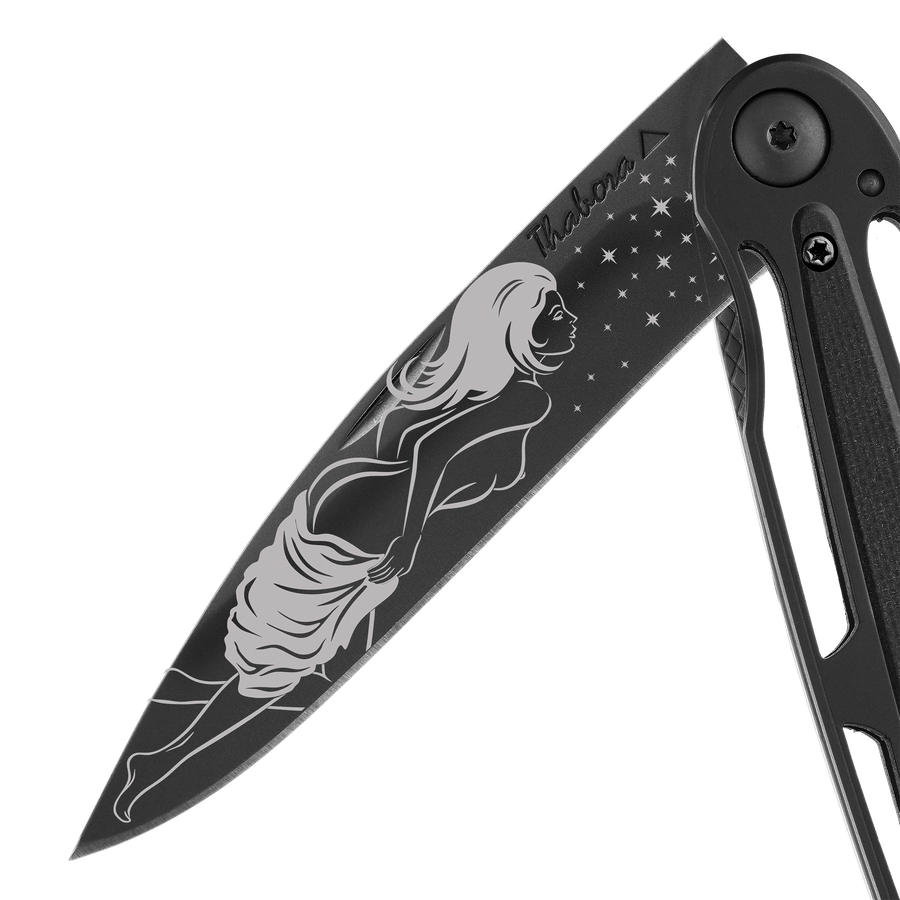 Couteau acier finition titane noir plaquette centrale résine g10 noir motif «femme dénudée»