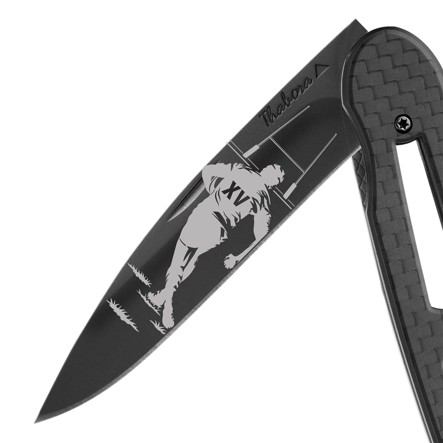 Couteau acier finition titane noir plaquette ajourée carbone motif «rugby»