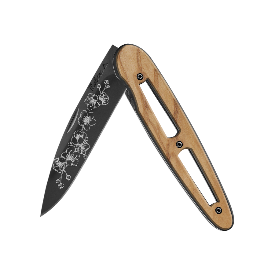 Couteau acier finition titane noir plaquette ajourée bois clair motif «arbre fleuri»