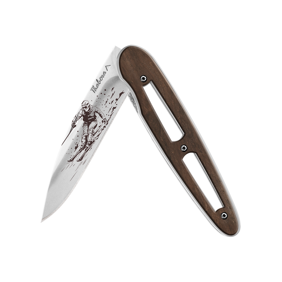 Couteau acier finition brillante plaquette ajourée bois foncé motif «skieur»