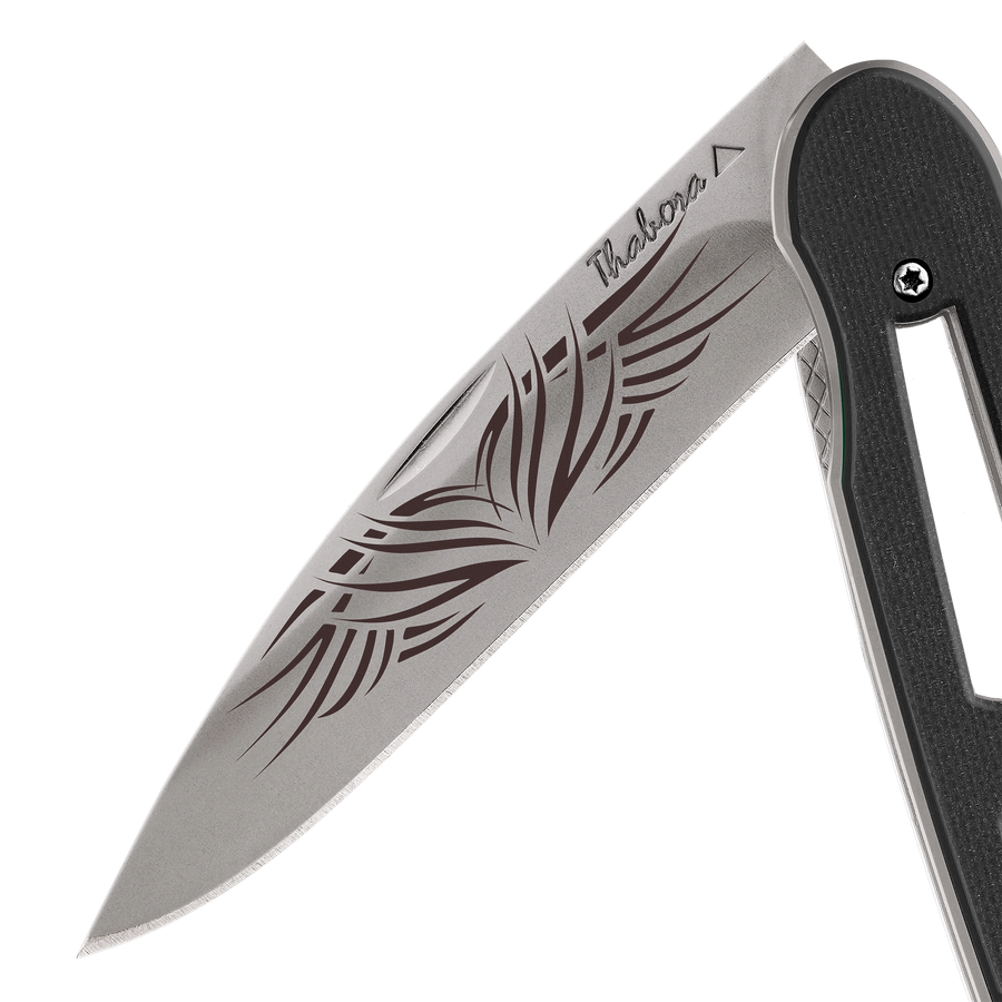 Couteau acier finition titane gris plaquette ajourée résine g10 noir motif «tribal»