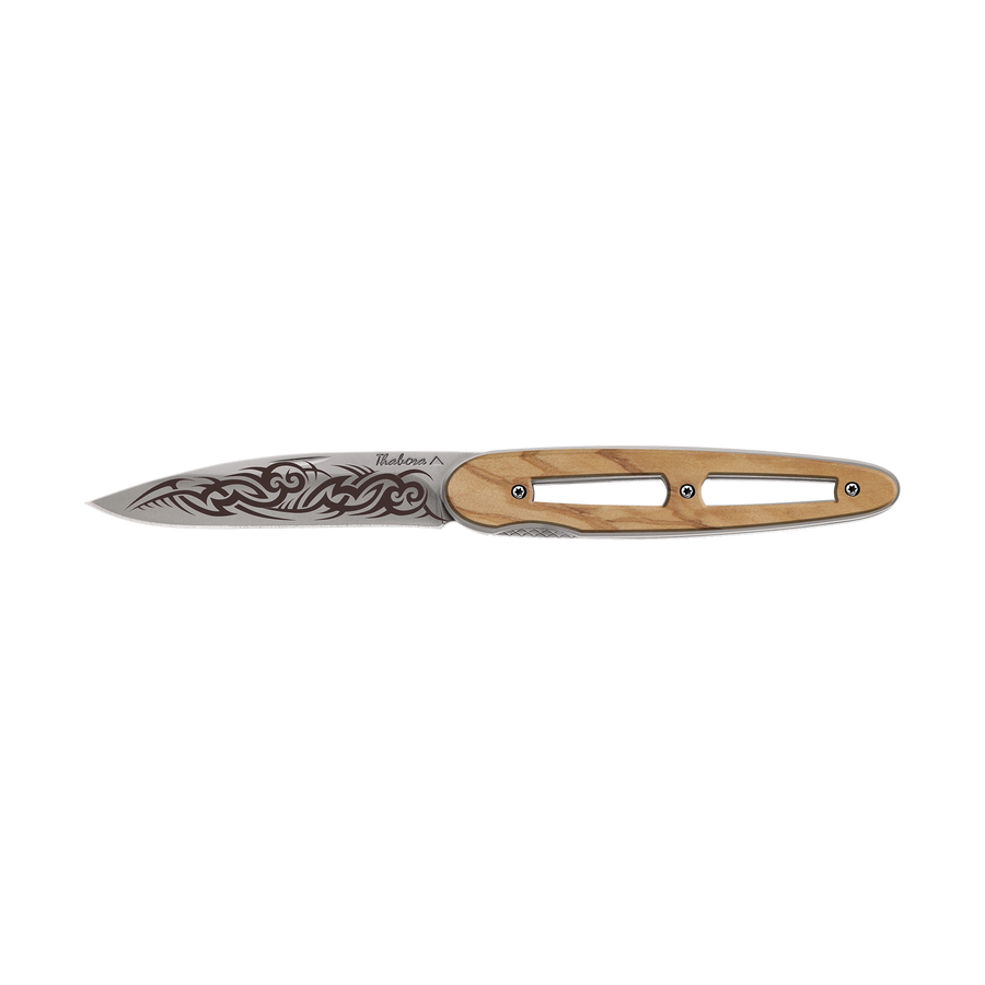 Couteau acier finition titane gris plaquette ajourée bois clair motif «tribal gothique»