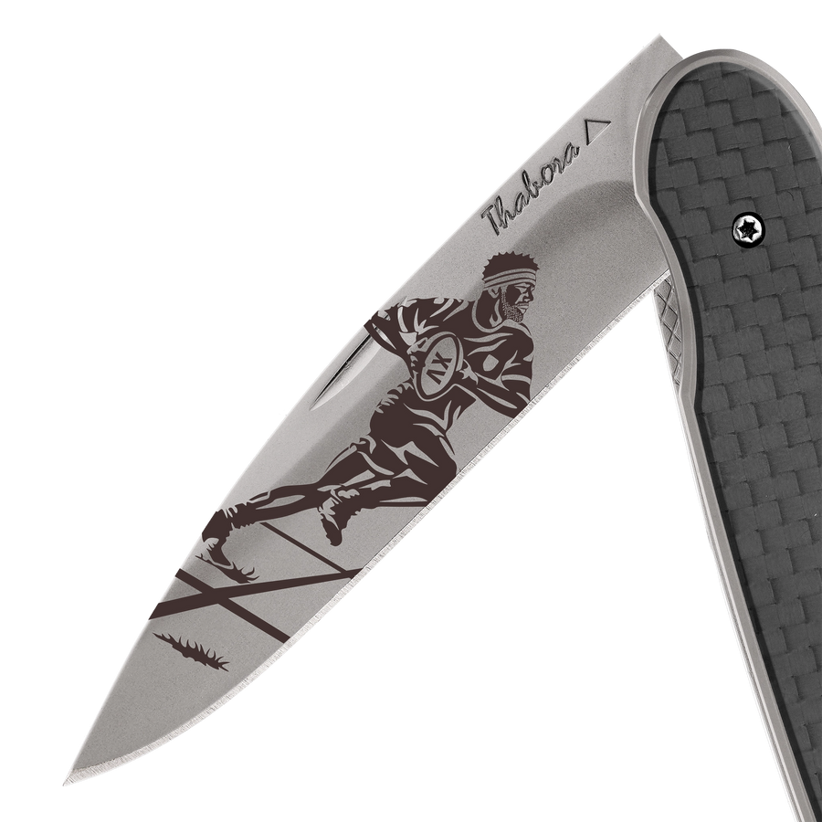 Couteau acier finition titane gris plaquette pleine carbone motif «rugbyman»
