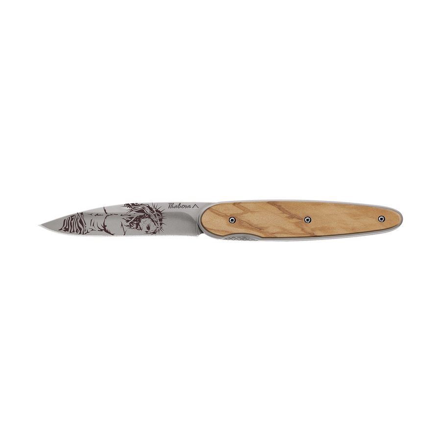 Couteau acier finition titane gris plaquette pleine bois clair motif «christ»