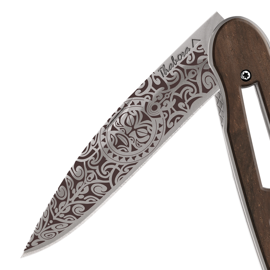 Couteau acier finition titane gris plaquette ajourée bois foncé motif «tiki»