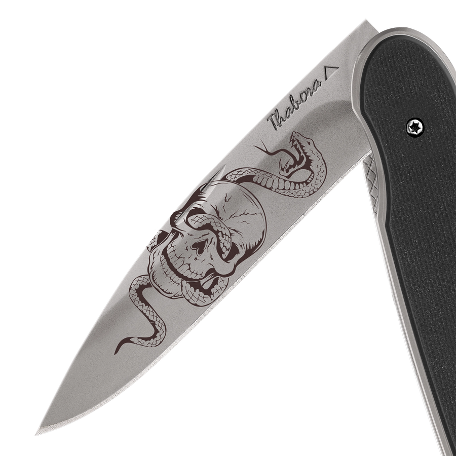 Couteau acier finition titane gris plaquette pleine résine g10 noir motif «tête de mort serpent»