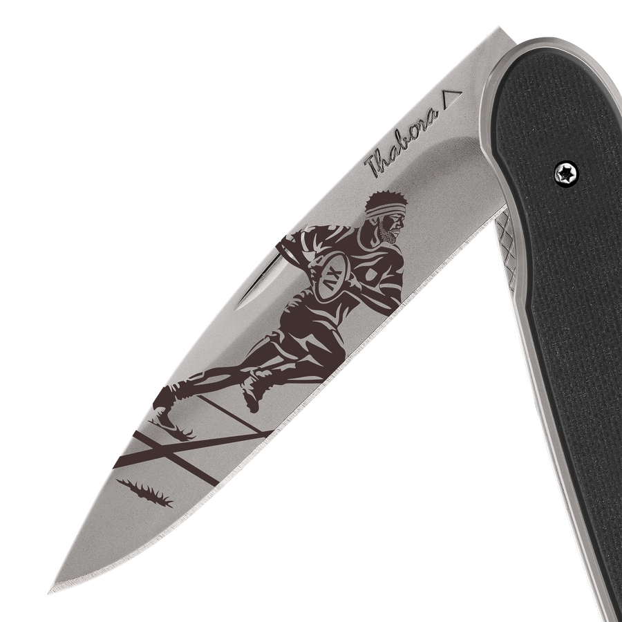 Couteau acier finition titane gris plaquette pleine résine g10 noir motif «rugbyman»
