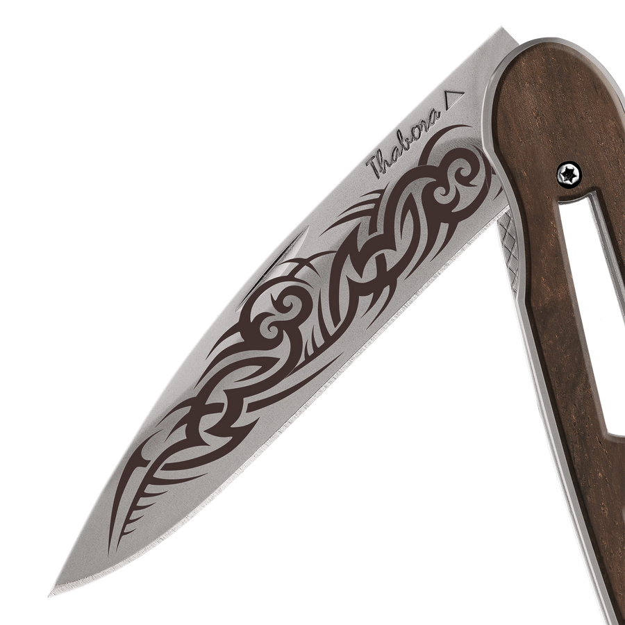 Couteau acier finition titane gris plaquette ajourée bois foncé motif «tribal gothique»
