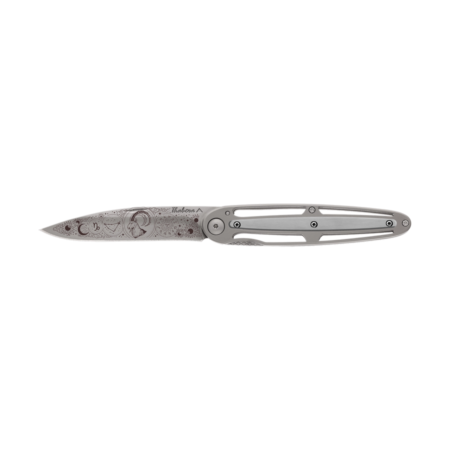 Couteau acier finition titane gris plaquette centrale acier brossé motif «zodiaque capricorne»