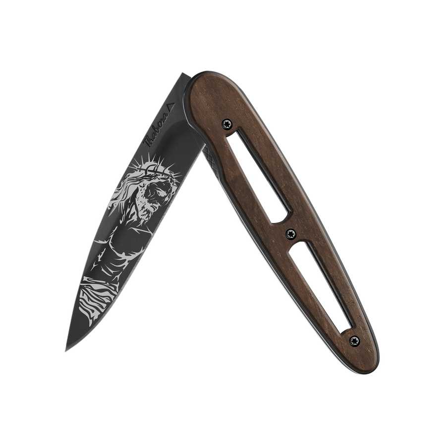 Couteau acier finition titane noir plaquette ajourée bois foncé motif «christ»