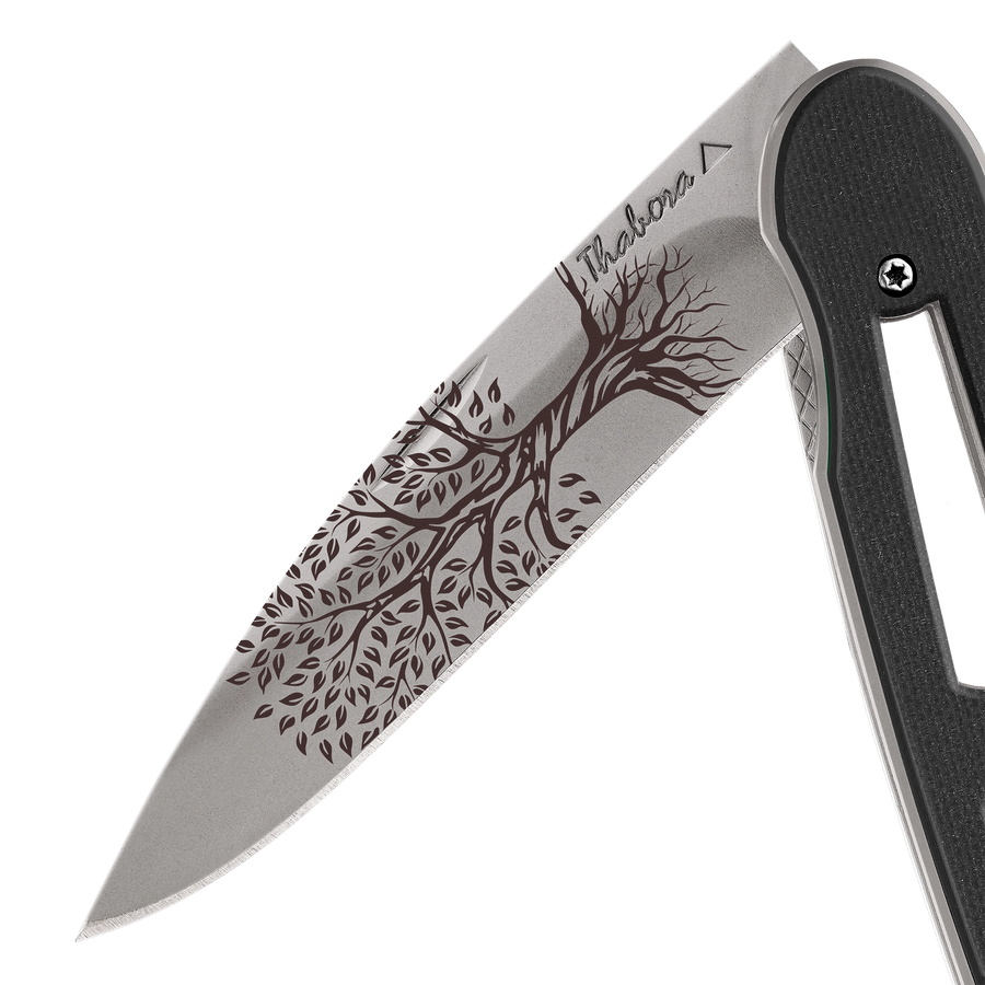 Couteau acier finition titane gris plaquette ajourée résine g10 noir motif «arbre de vie»