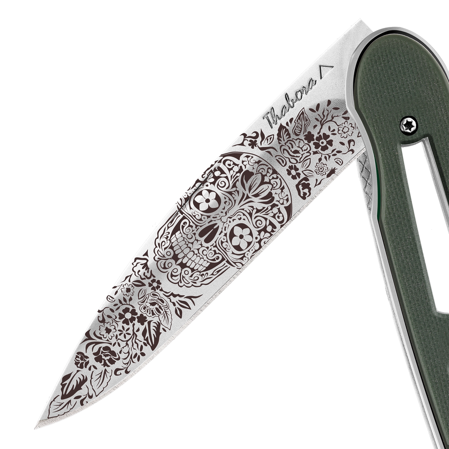Couteau acier finition brillante plaquette ajourée résine g10 kaki motif «tête mexicaine»