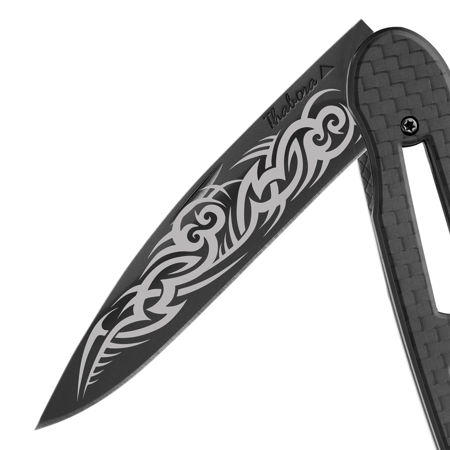 Couteau acier finition titane noir plaquette ajourée carbone motif «tribal gothique»