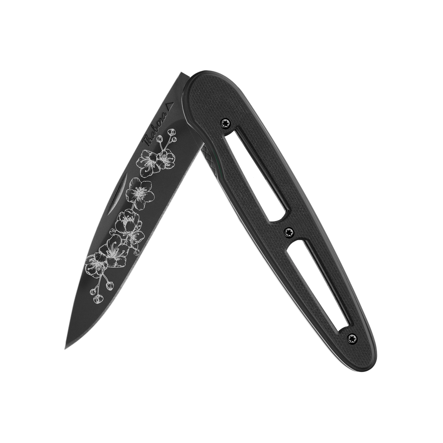 Couteau acier finition titane noir plaquette ajourée résine g10 noir motif «arbre fleuri»