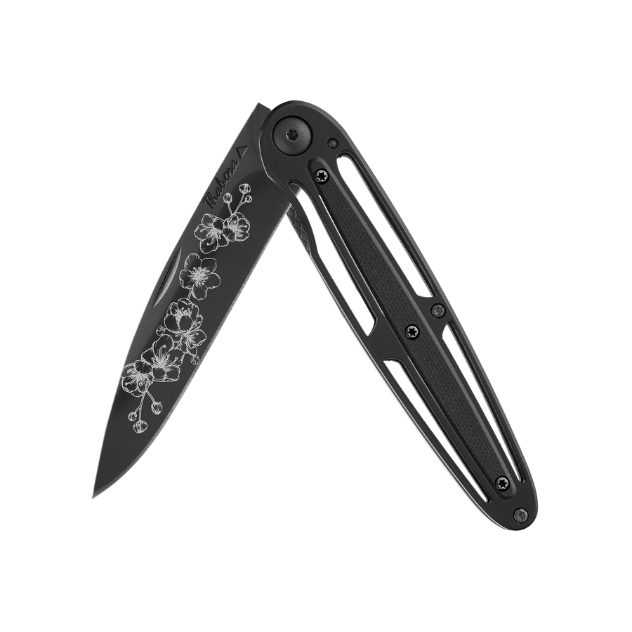 Couteau acier finition titane noir plaquette centrale résine g10 noir motif «arbre fleuri»