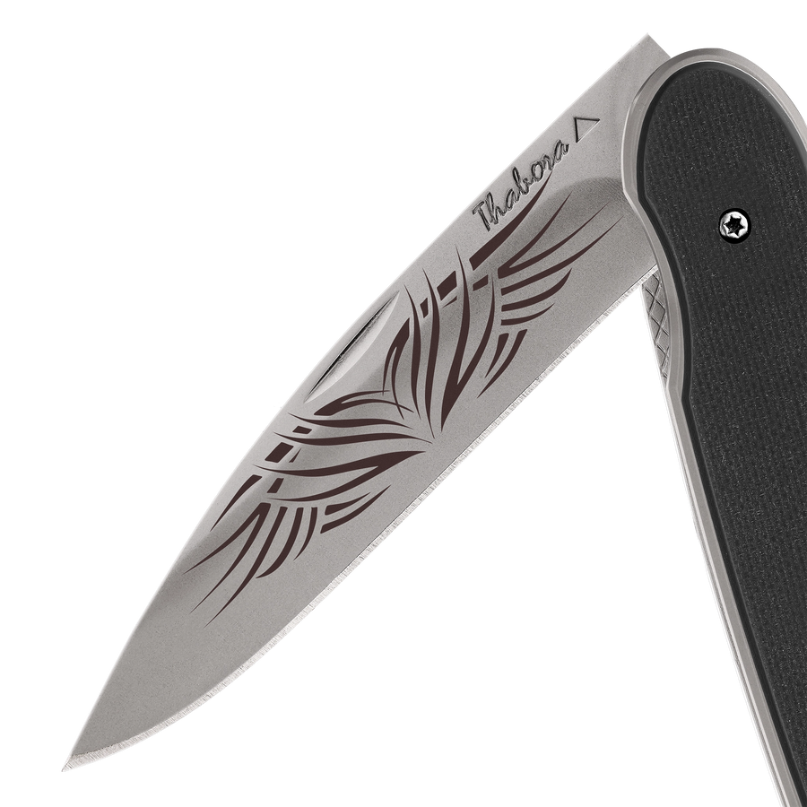 Couteau acier finition titane gris plaquette pleine résine g10 noir motif «tribal»