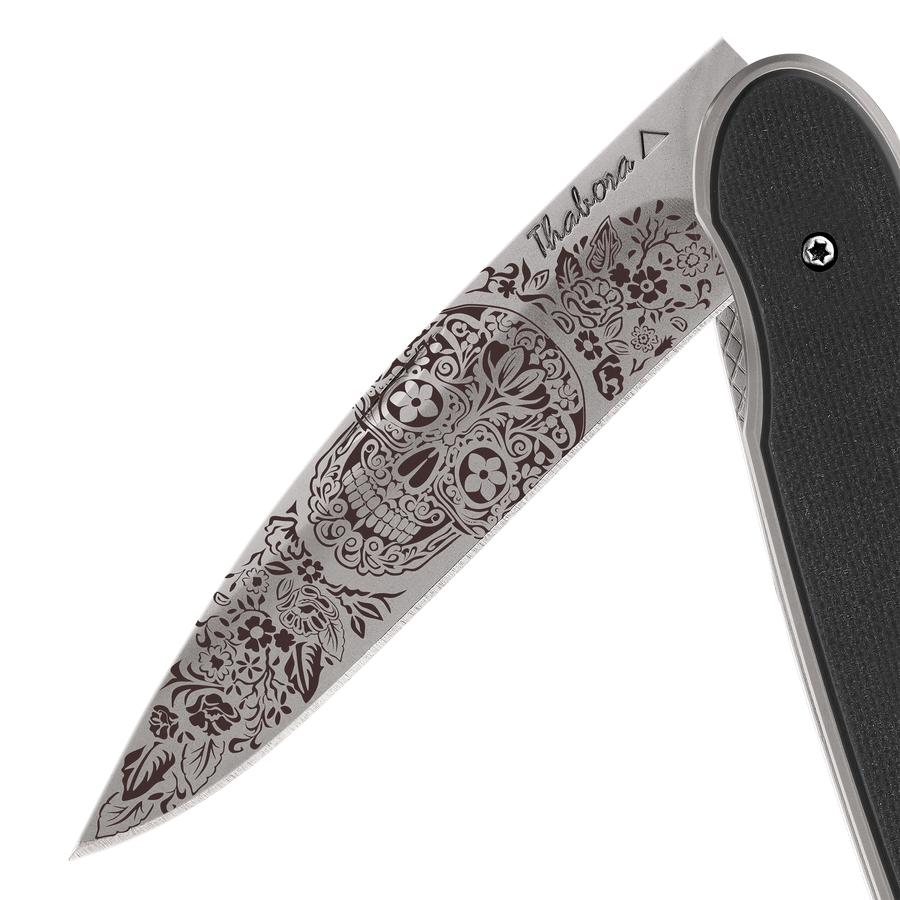 Couteau acier finition titane gris plaquette pleine résine g10 noir motif «tête mexicaine»