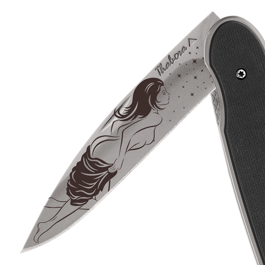 Couteau acier finition titane gris plaquette pleine résine g10 noir motif «femme dénudée»