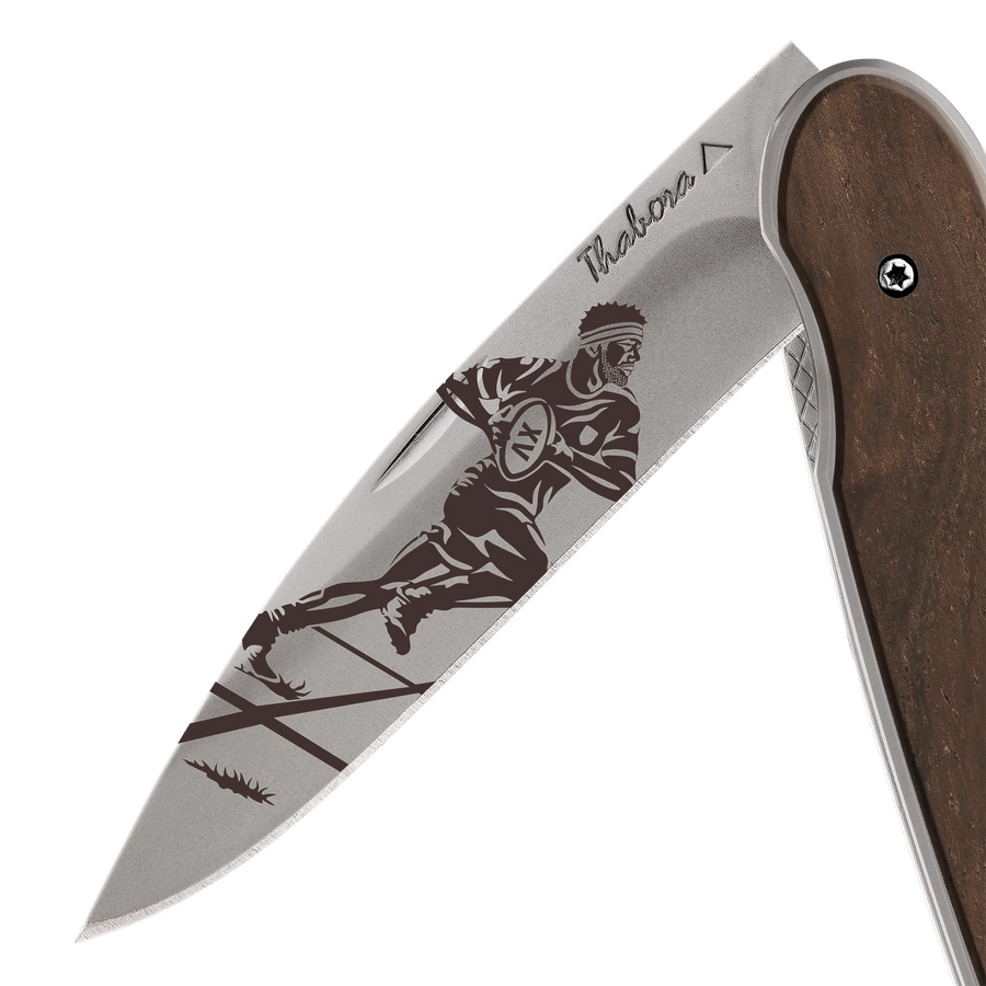Couteau acier finition titane gris plaquette pleine bois foncé motif «rugbyman»