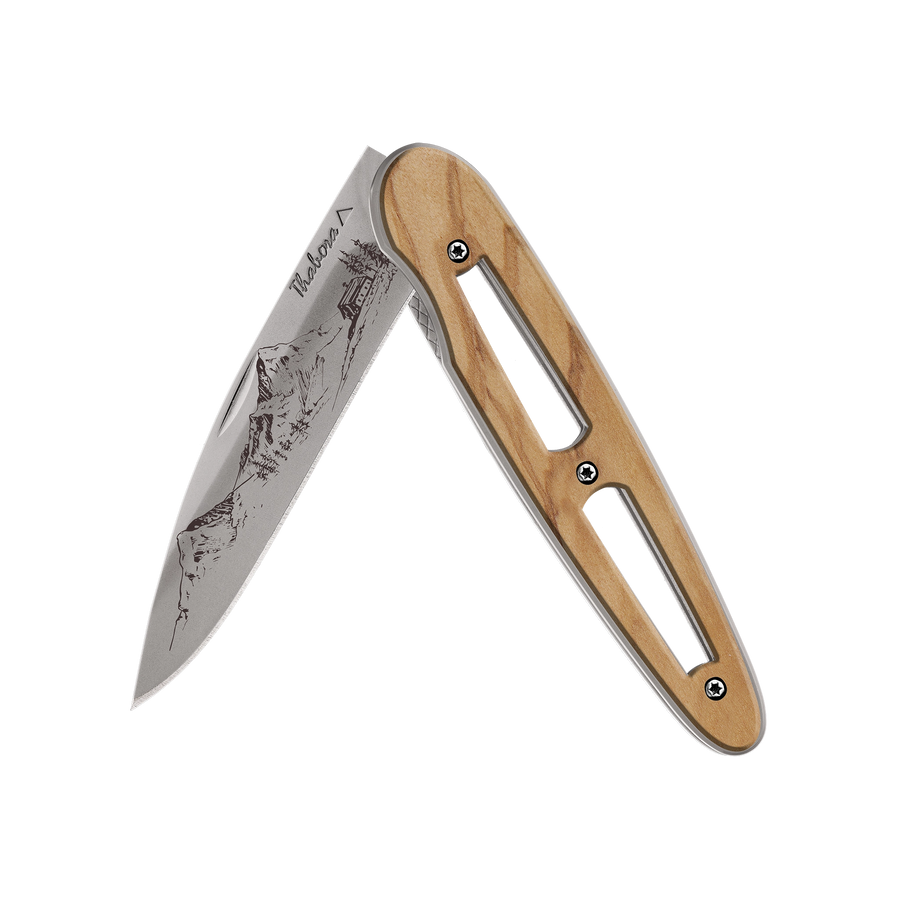 Couteau acier finition titane gris plaquette ajourée bois clair motif «montagne»
