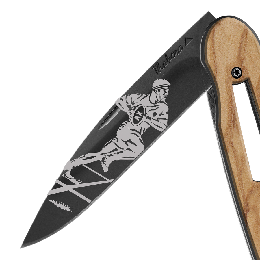 Couteau acier finition titane noir plaquette ajourée bois clair motif «rugbyman»