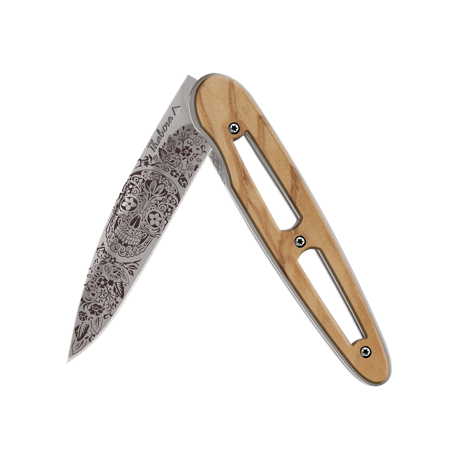 Couteau acier finition titane gris plaquette ajourée bois clair motif «tête mexicaine»